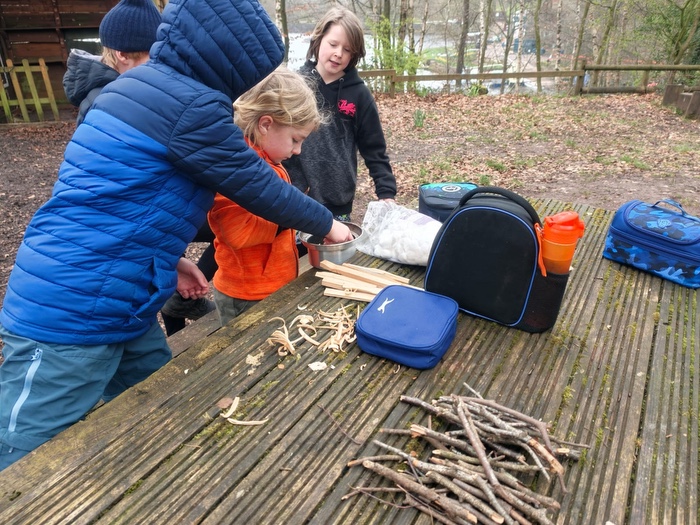 Young children preparing kindling for a bushcraft activity